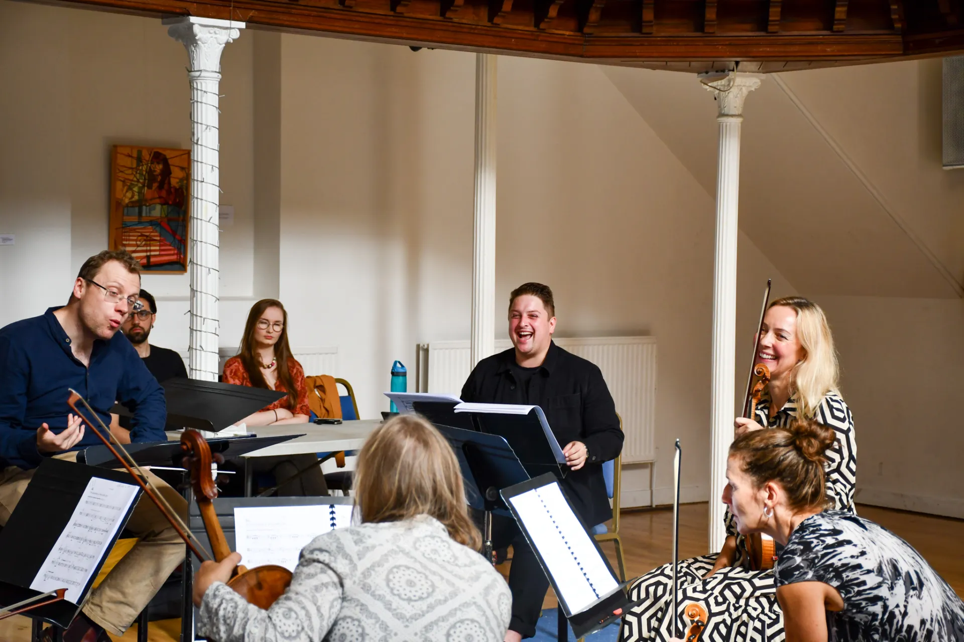 Musicians laugh during a rehearsal