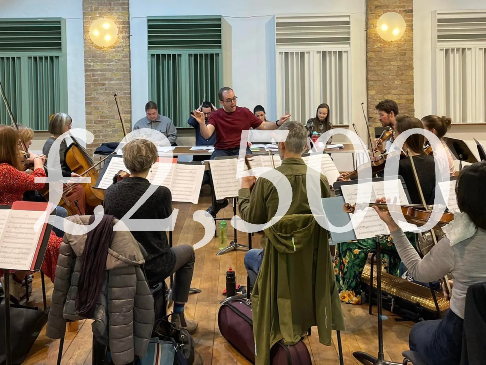 A conductor leads musicians in a rehearsal